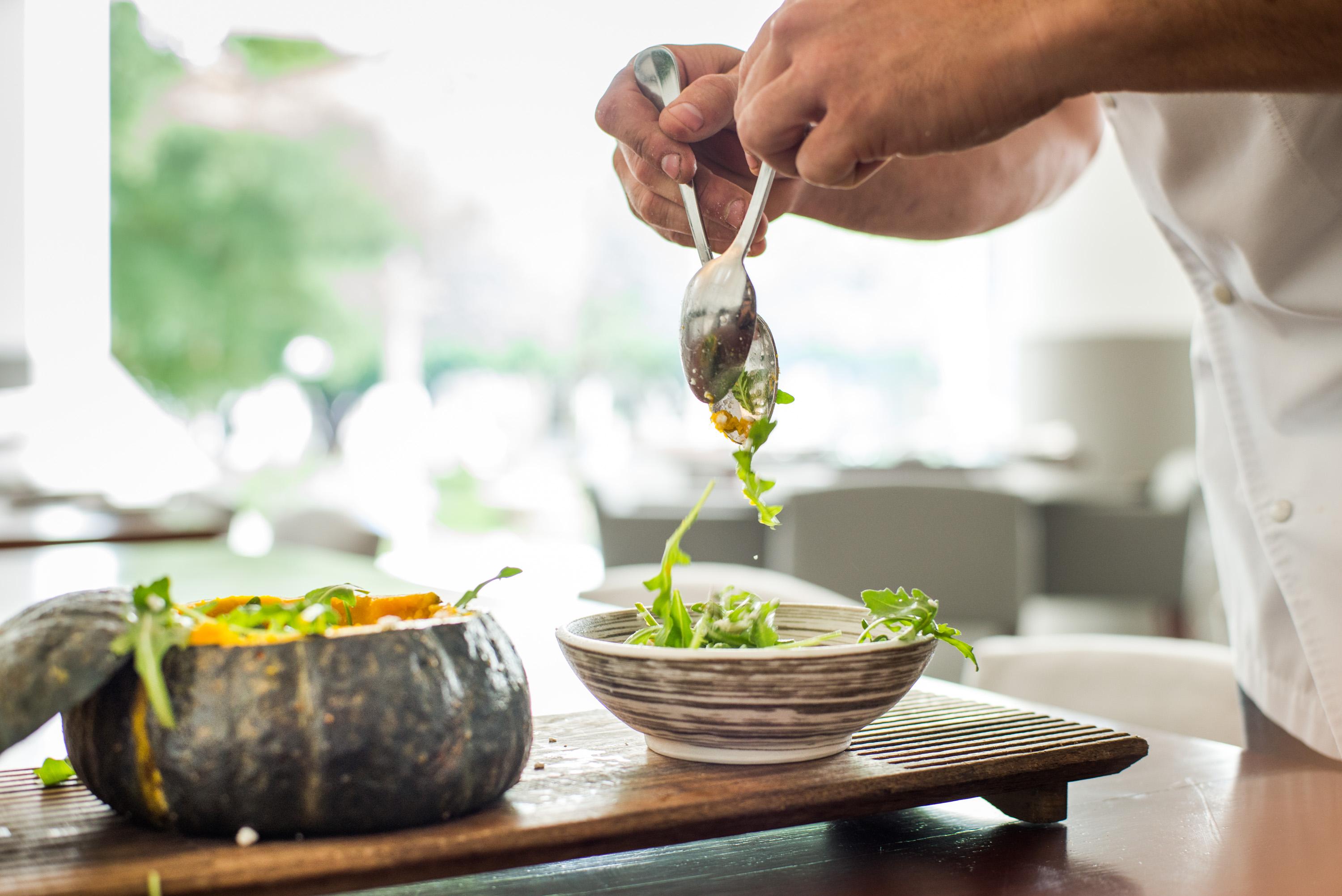 Salat wird mit silbernen Löffeln geworfen